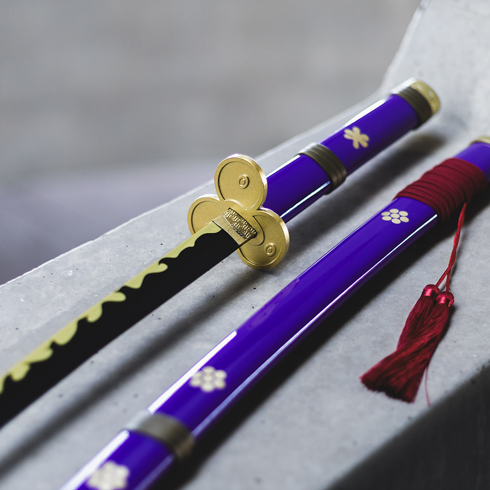 Zoro Roronoa’s Enma sword - a purple sword with golden accents and a trefoil shaped guard - resting on a grey concrete background.