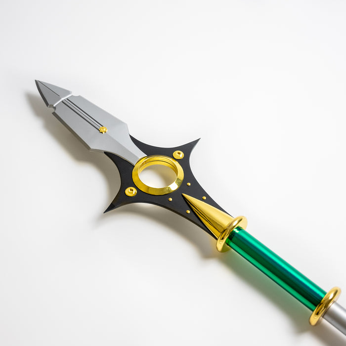 Closeup of the spearhead for King's Spirit Spear Chastiefol made of metal from the anime and manga series Seven Deadly Sins. It is a silver spear with green and gold detailing.