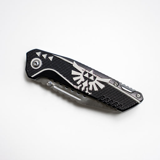 Black Folding knife with the Legend of Zelda Hylian triforce symbol from The Legend of Zelda series, closed