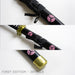 Details of Roronoa Zoro's Shusui Katana First Edition. Closeups of the black sheath with gold accents and pink detailing. 