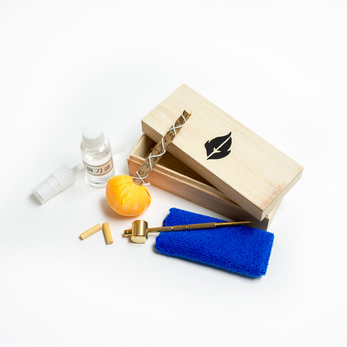Lubricant Sword Care Kit from Fire and Steel. Includes a wooden box, cleaning cloth, uchiko ball, Mekugi-Nuki (hammer), spare Mekugi dowels and maintenance oil.